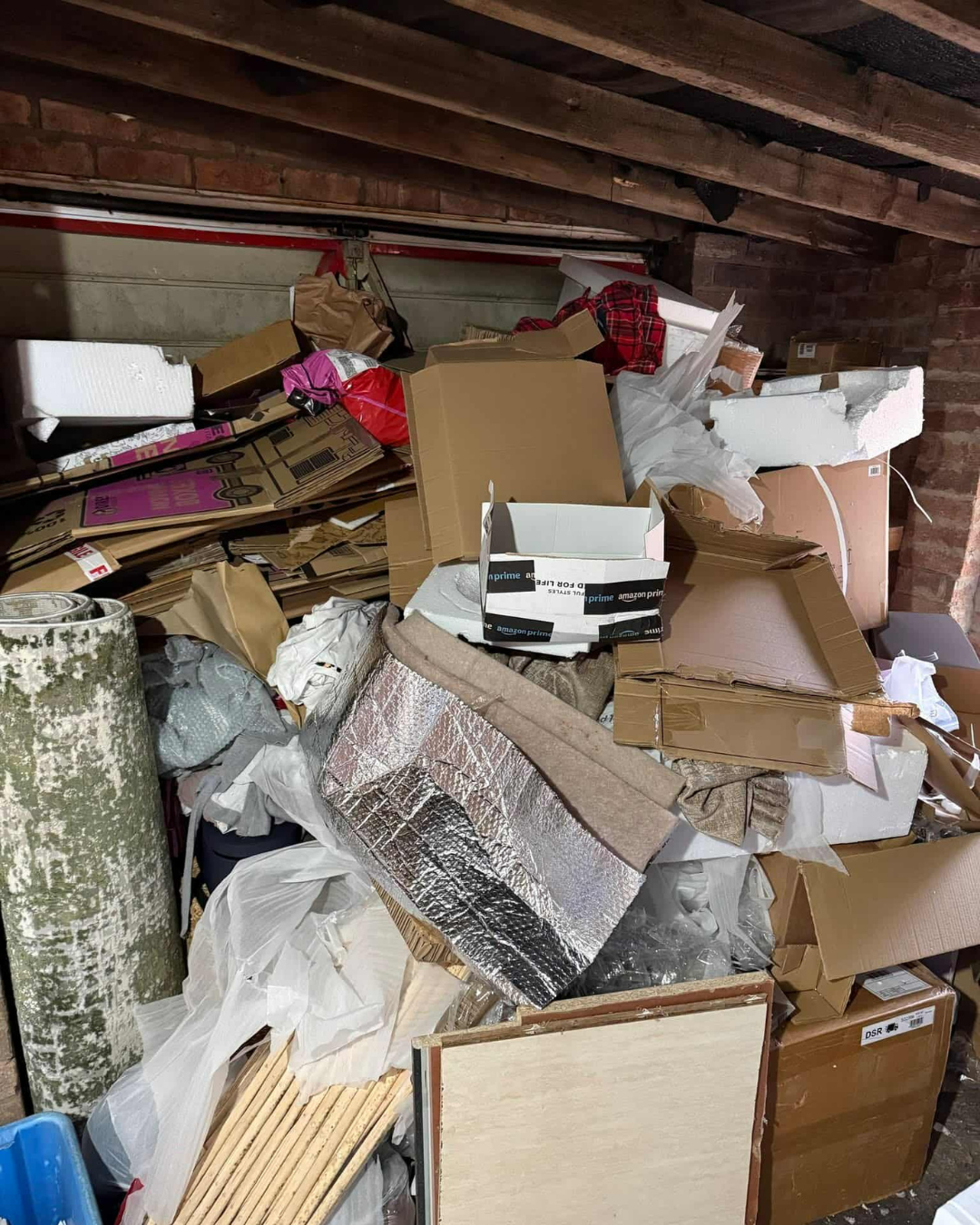 Inside of a garage with rubbish piled to the top