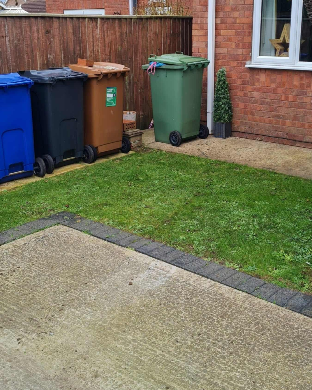 Cleared garden with bins visible